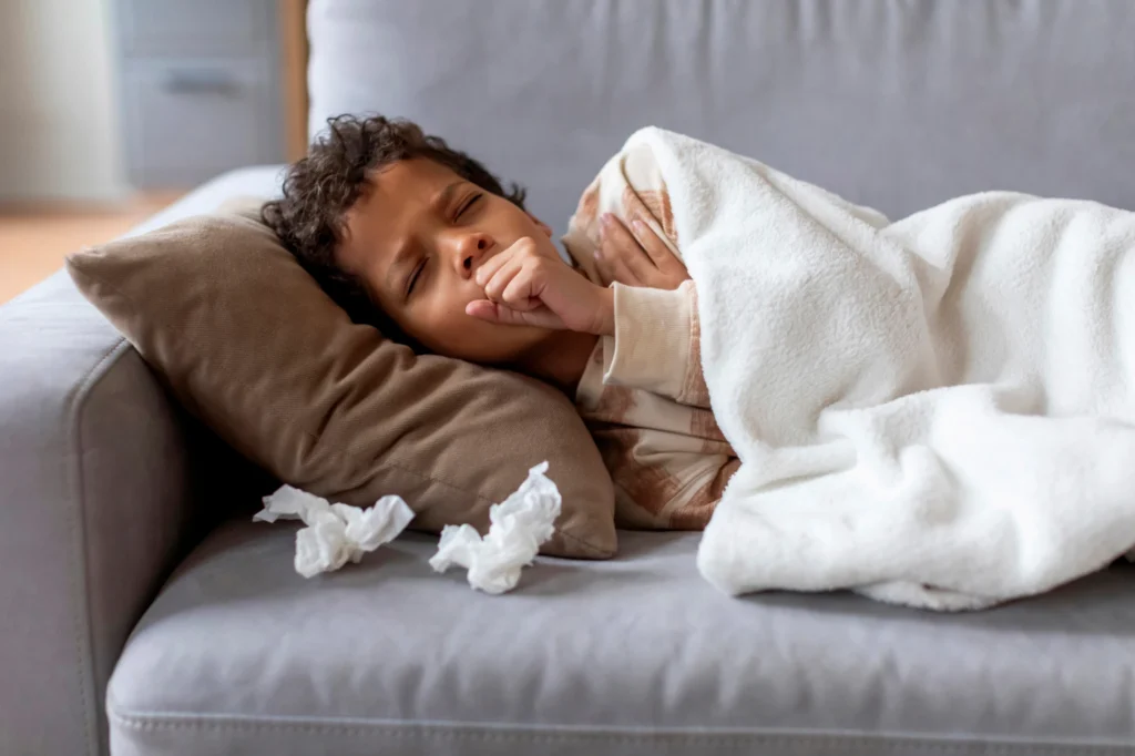 child laying on the couch with a cough from croup