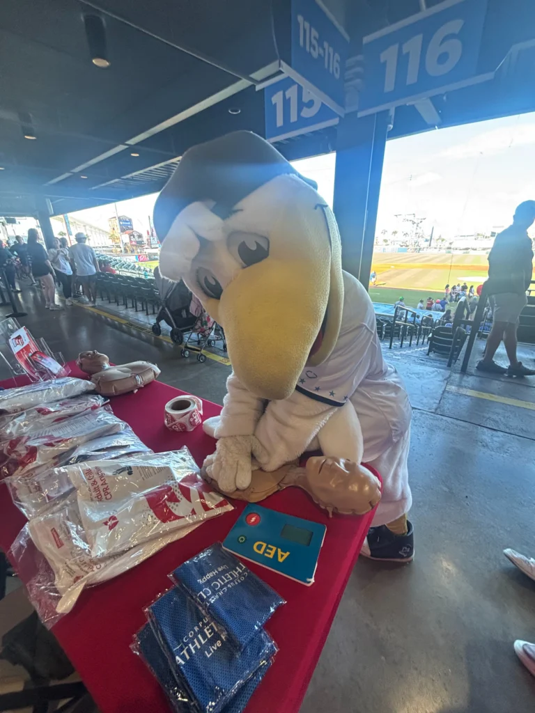 Corpus Christi Hooks mascot trying CPR kits provided by TLC Complete Care